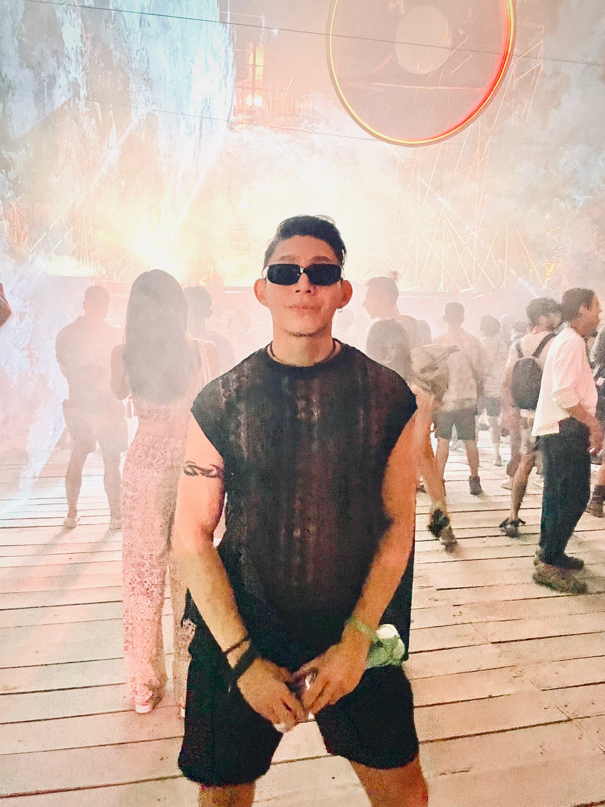 Man wearing the WONGSO Black Lace Festival Shirt and sunglasses in front of a smoke filled festival stage