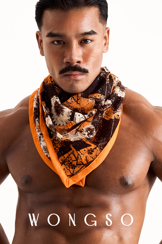 Close-up of a male model wearing the WONGSO sheer orange floral festival bandana tied around his neck.