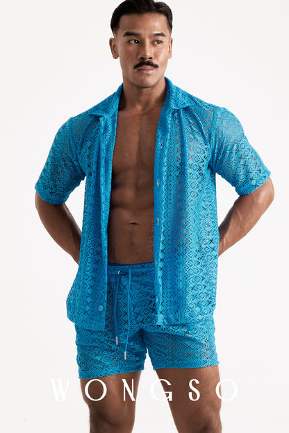 Full body front view of a muscular male model wearing the Boheme Sheer Lace Relaxed Shirt in Bali Blue by WONGSO. The sheer blue lace camp collar shirt for men is styled unbuttoned, showcasing premium queer bold men's fashion.