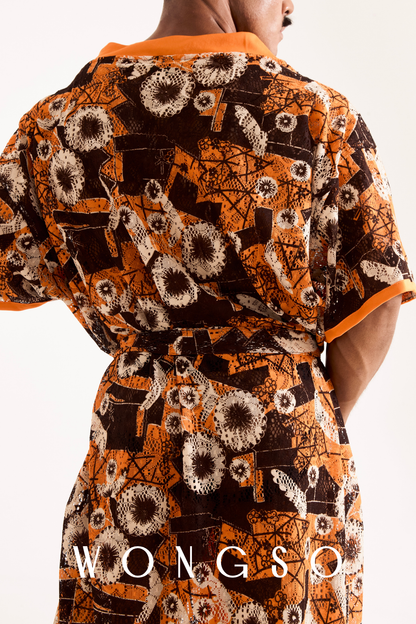 Close-up detail of the sheer orange floral lace fabric and orange trim on a men's festival kimono.