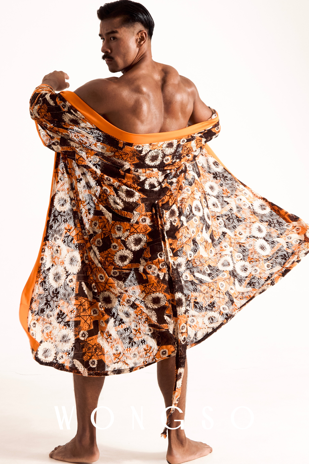 Male model showcasing the flowing sheer sleeves and translucent drape of the WONGSO orange floral lace kimono.
