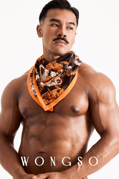 Side profile of a male model highlighting the WONGSO sunset orange floral festival bandana styled around the neck.