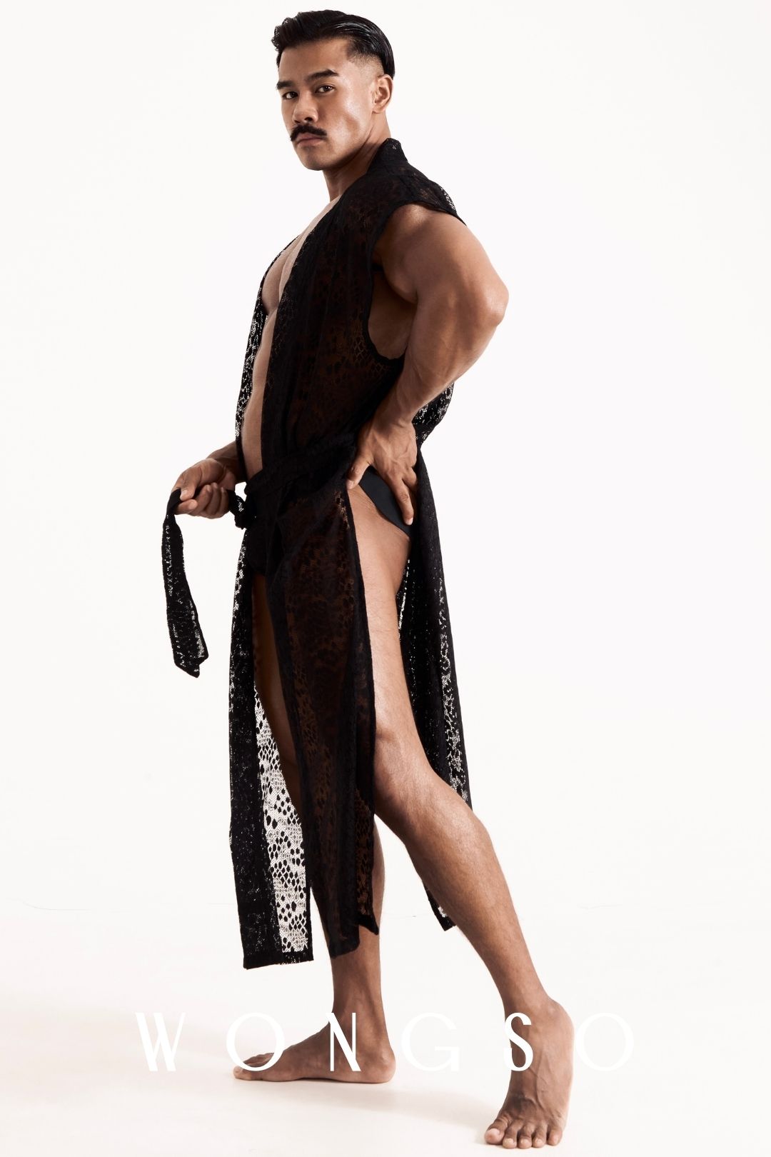 Side view of the WONGSO leopard print lace kimono on a male model, showing the high side-slit cut mid-stride. Men's high-slit kimono for festivals and resort wear.