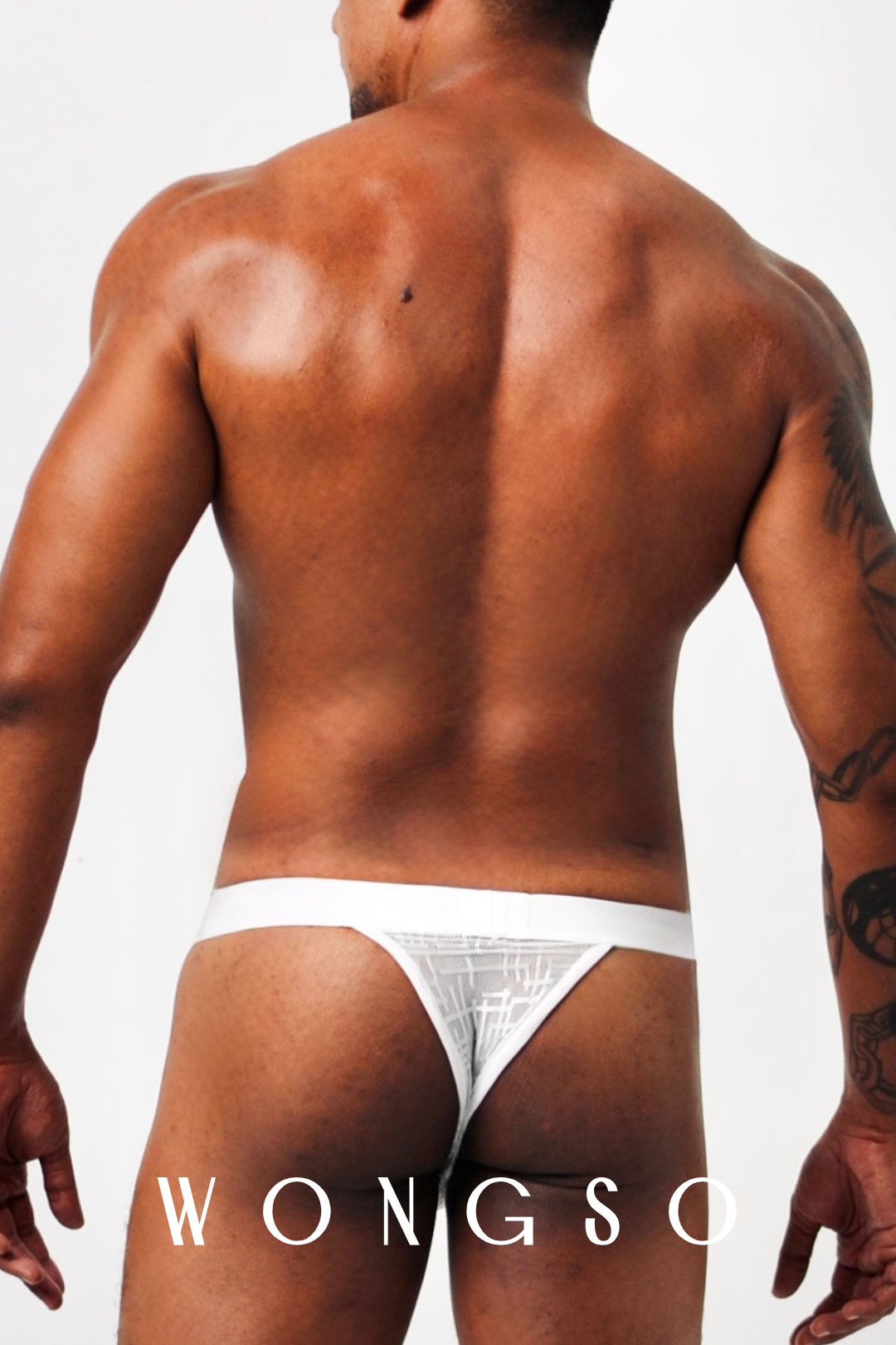 Close-up Back: Detail of sheer silver-white fabric on men’s thong back strap – Libertine Collection