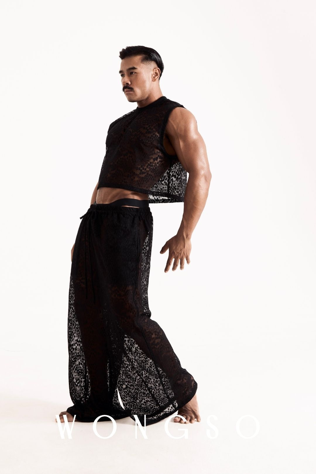 Full body front view of a male model wearing the WONGSO leopard print lace crop top, boxy fit with dropped shoulder. Men's festival and resort wear.