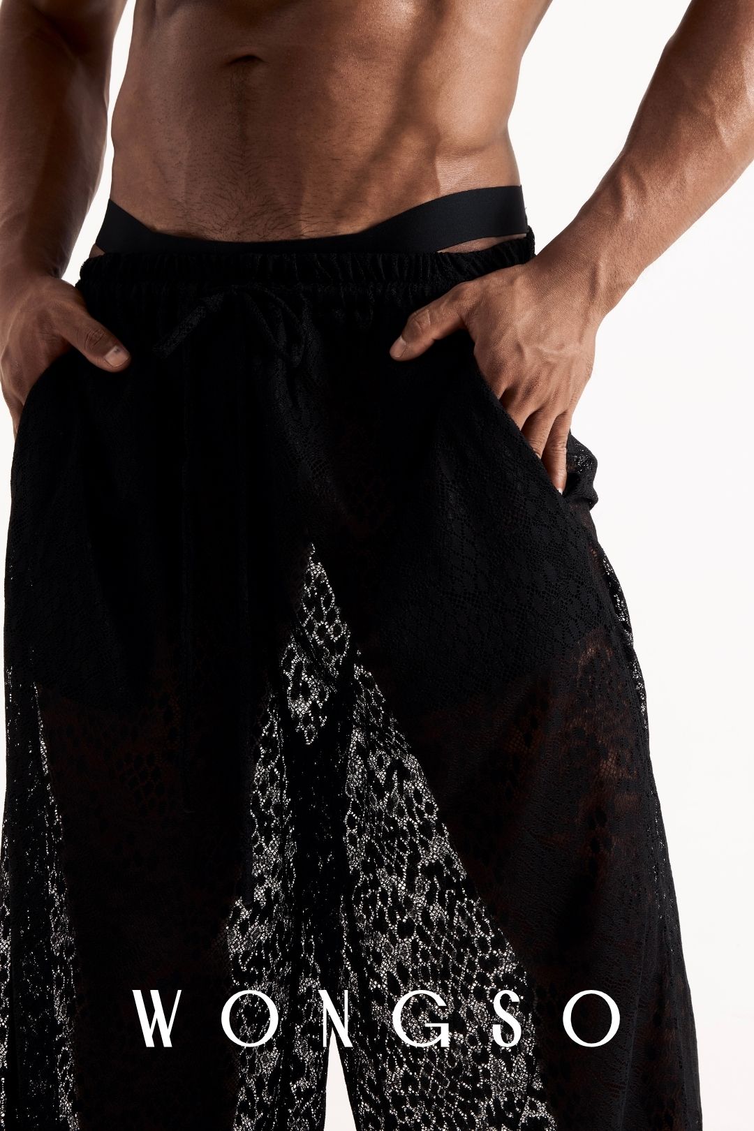 Close-up front view of the leopard print lace wide-leg trousers, showing the sheer fabric and waistband detail. Men's sheer festival trousers.
