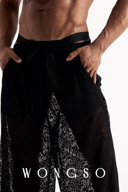 Close-up front view of the leopard print lace wide-leg trousers, showing the sheer fabric and waistband detail. Men's sheer festival trousers.
