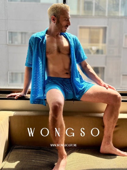 Model in the Bali Blue lace shirt seated by a window