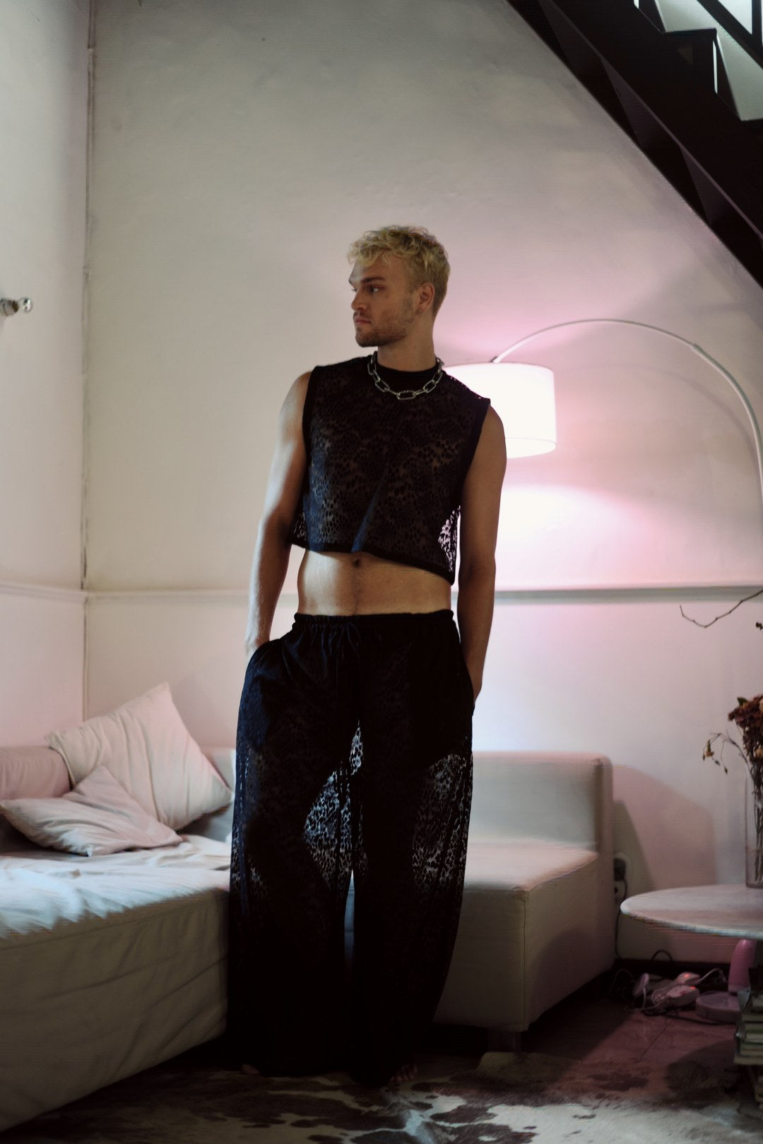 Model in the Libertine leopard lace crop top and wide leg pants by a pink lamp