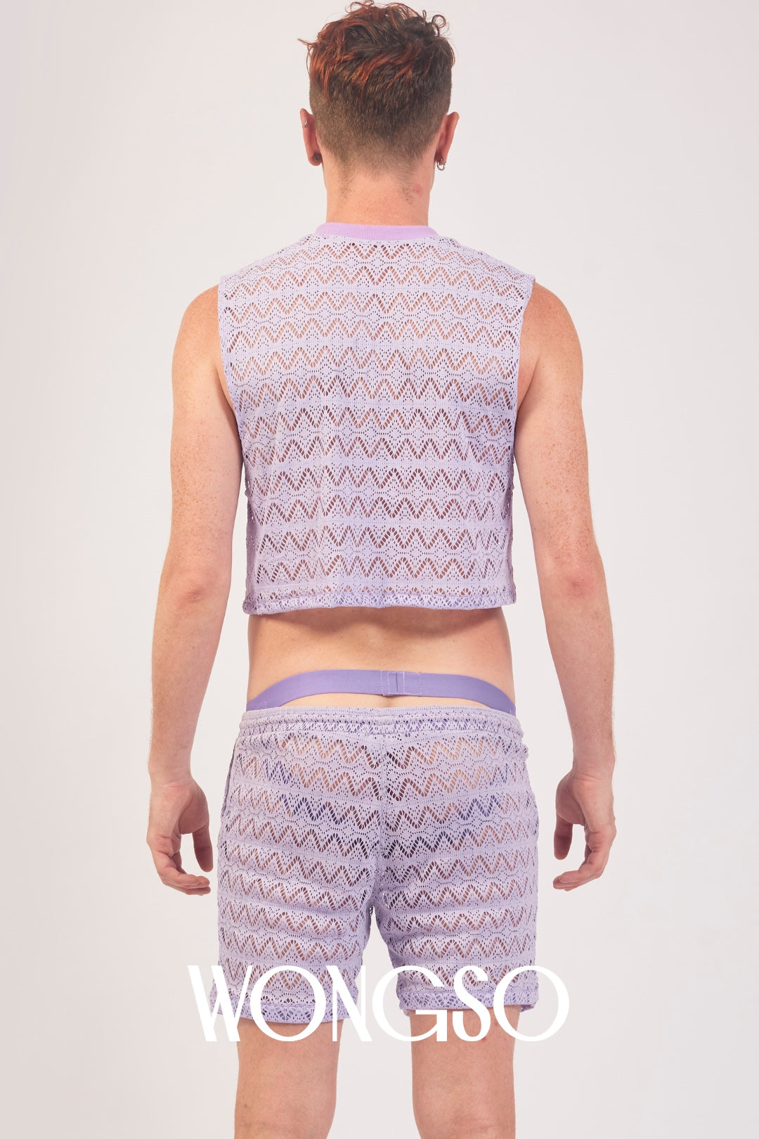 Queer model posing in the WONGSO Lilac Lace Crop Top, sheer mesh detail