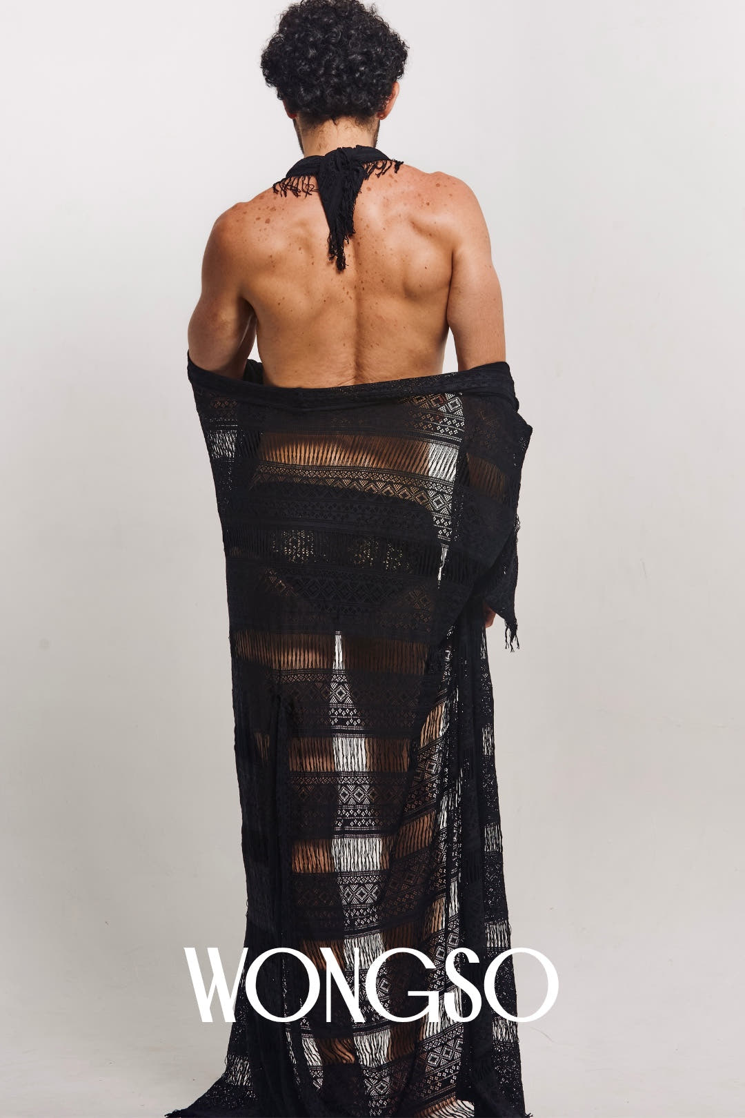 Back view of a model walking in the WONGSO sheer lace robe for men