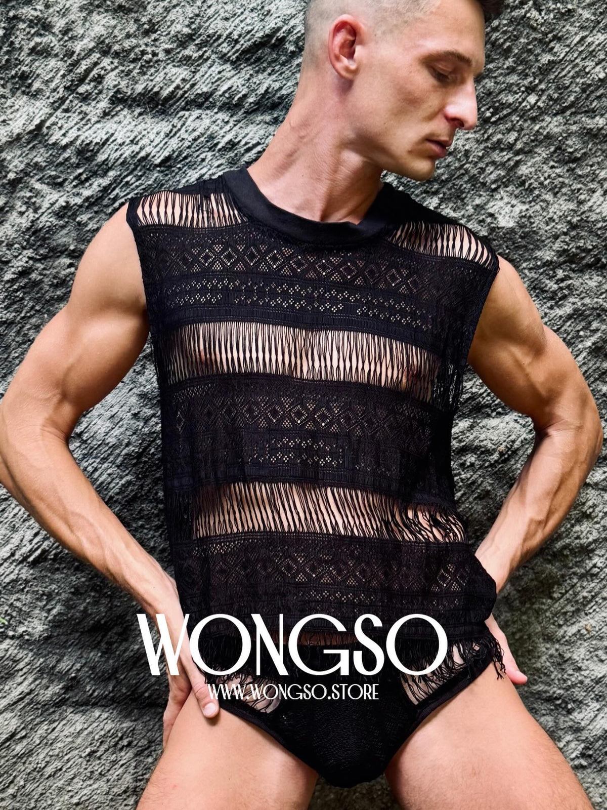 Model in the Fringe Black tank against a stone wall