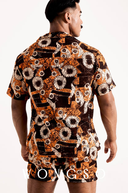 Back view of a man wearing a sheer orange floral relaxed fit festival shirt from the WONGSO Boheme collection