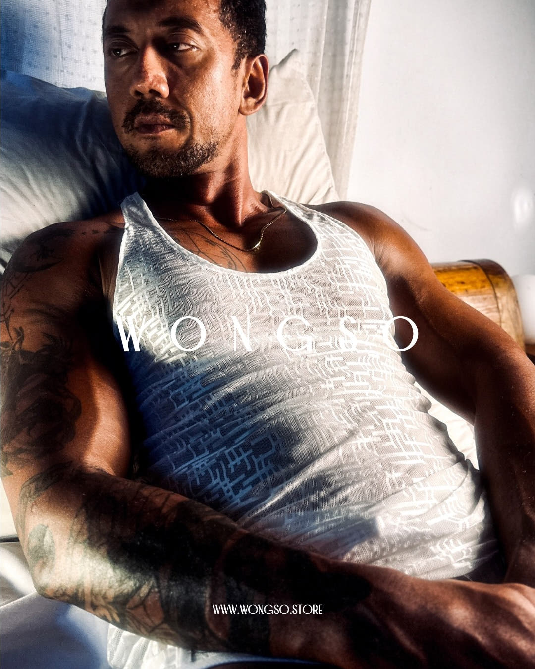 Model in the Silver White sheer muscle tank, reclining