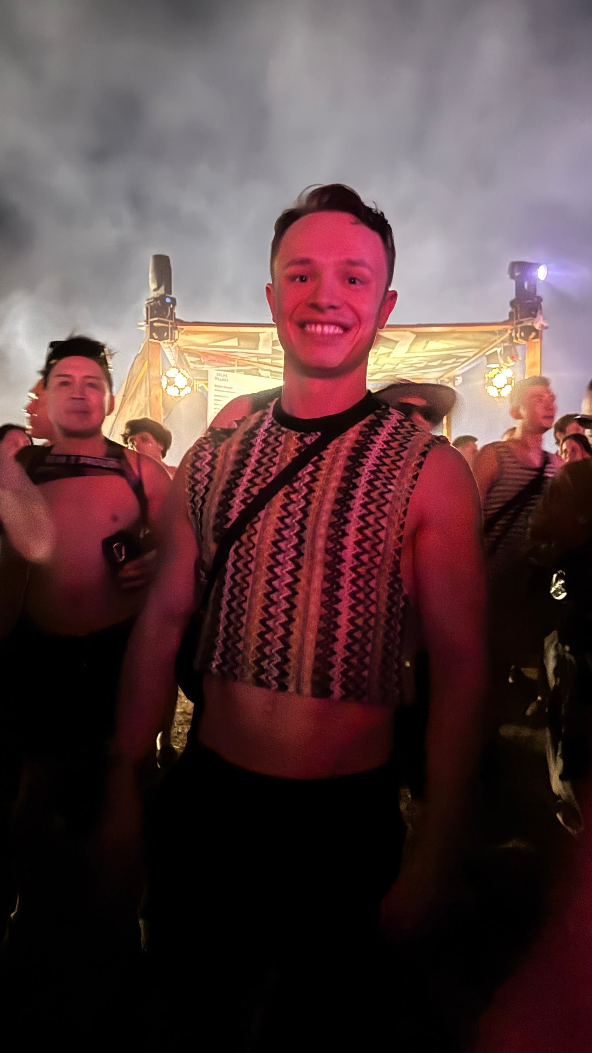 Festivalgoer wearing the WONGSO Green Knitted Crop Top in a crowd under pink stage light